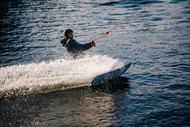 Gün batımında Tibet öküzü kostümü giymiş bir adam Kiev 'deki aşırı parktaki bir wakeboard üzerinde sıçrama tahtasından atlıyor. Ukrayna. Yüksek kalite fotoğraf