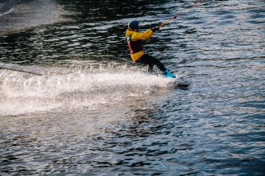 Gün batımında Tibet öküzü kostümü giymiş bir adam Kiev 'deki aşırı parktaki bir wakeboard üzerinde sıçrama tahtasından atlıyor. Ukrayna. Yüksek kalite fotoğraf