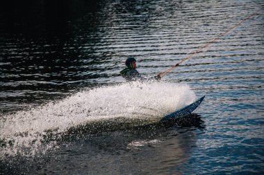 Gün batımında Tibet öküzü kostümü giymiş bir adam Kiev 'deki aşırı parktaki bir wakeboard üzerinde sıçrama tahtasından atlıyor. Ukrayna. Yüksek kalite fotoğraf