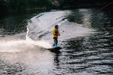 Gün batımında Tibet öküzü kostümü giymiş bir adam Kiev 'deki aşırı parktaki bir wakeboard üzerinde sıçrama tahtasından atlıyor. Ukrayna. Yüksek kalite fotoğraf