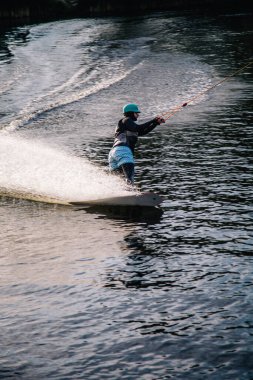 Gün batımında Tibet öküzü kostümü giymiş bir adam Kiev 'deki aşırı parktaki bir wakeboard üzerinde sıçrama tahtasından atlıyor. Ukrayna. Yüksek kalite fotoğraf