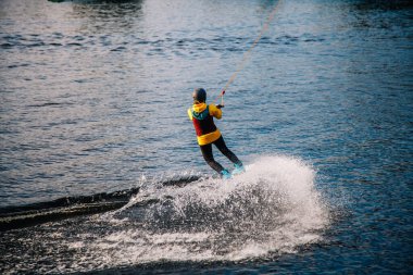 Gün batımında Tibet öküzü kostümü giymiş bir adam Kiev 'deki aşırı parktaki bir wakeboard üzerinde sıçrama tahtasından atlıyor. Ukrayna. Yüksek kalite fotoğraf