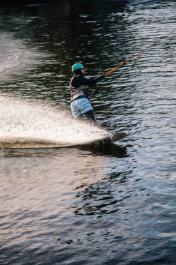 Gün batımında Tibet öküzü kostümü giymiş bir adam Kiev 'deki aşırı parktaki bir wakeboard üzerinde sıçrama tahtasından atlıyor. Ukrayna. Yüksek kalite fotoğraf