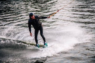 Gün batımında Tibet öküzü kostümü giymiş bir adam Kiev 'deki aşırı parktaki bir wakeboard üzerinde sıçrama tahtasından atlıyor. Ukrayna. Yüksek kalite fotoğraf