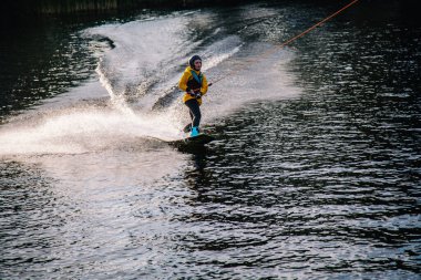 Gün batımında Tibet öküzü kostümü giymiş bir adam Kiev 'deki aşırı parktaki bir wakeboard üzerinde sıçrama tahtasından atlıyor. Ukrayna. Yüksek kalite fotoğraf
