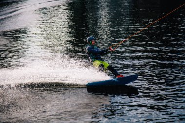 Gün batımında Tibet öküzü kostümü giymiş bir adam Kiev 'deki aşırı parktaki bir wakeboard üzerinde sıçrama tahtasından atlıyor. Ukrayna. Yüksek kalite fotoğraf