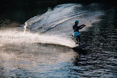 Gün batımında Tibet öküzü kostümü giymiş bir adam Kiev 'deki aşırı parktaki bir wakeboard üzerinde sıçrama tahtasından atlıyor. Ukrayna. Yüksek kalite fotoğraf