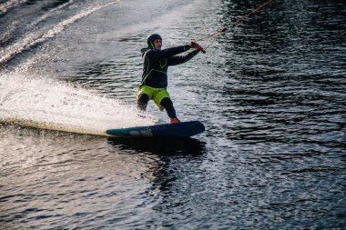 Gün batımında Tibet öküzü kostümü giymiş bir adam Kiev 'deki aşırı parktaki bir wakeboard üzerinde sıçrama tahtasından atlıyor. Ukrayna. Yüksek kalite fotoğraf