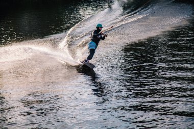 Gün batımında Tibet öküzü kostümü giymiş bir adam Kiev 'deki aşırı parktaki bir wakeboard üzerinde sıçrama tahtasından atlıyor. Ukrayna. Yüksek kalite fotoğraf