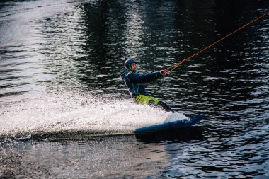 Gün batımında Tibet öküzü kostümü giymiş bir adam Kiev 'deki aşırı parktaki bir wakeboard üzerinde sıçrama tahtasından atlıyor. Ukrayna. Yüksek kalite fotoğraf