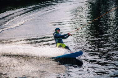 Gün batımında Tibet öküzü kostümü giymiş bir adam Kiev 'deki aşırı parktaki bir wakeboard üzerinde sıçrama tahtasından atlıyor. Ukrayna. Yüksek kalite fotoğraf