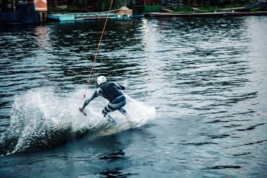 Gün batımında Tibet öküzü kostümü giymiş bir adam Kiev 'deki aşırı parktaki bir wakeboard üzerinde sıçrama tahtasından atlıyor. Ukrayna. Yüksek kalite fotoğraf