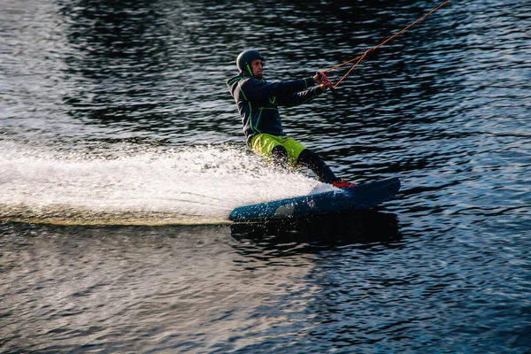 Gün batımında Tibet öküzü kostümü giymiş bir adam Kiev 'deki aşırı parktaki bir wakeboard üzerinde sıçrama tahtasından atlıyor. Ukrayna. Yüksek kalite fotoğraf
