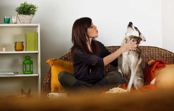 Mulher morena relaxante na sala de estar com Husky siberiano — Fotografia de Stock