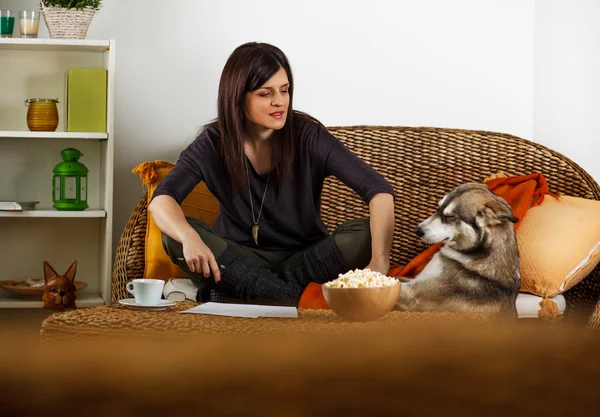Mulher morena relaxante na sala de estar com Husky siberiano — Fotografia de Stock