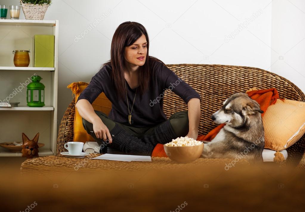 Brunette woman relaxing in living room with Siberian Husky
