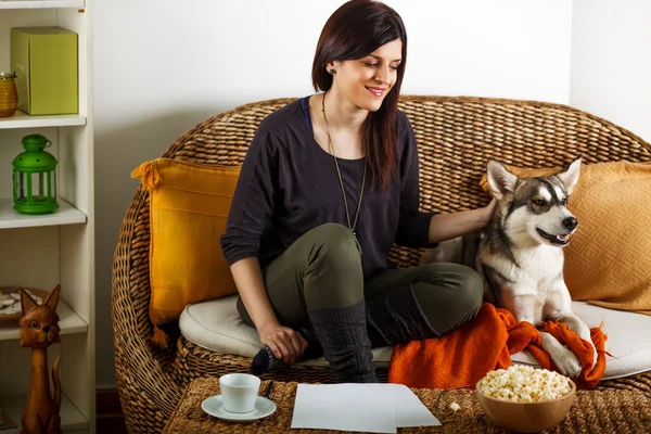 Mujer joven está jugando con el perro, en casa — Foto de Stock