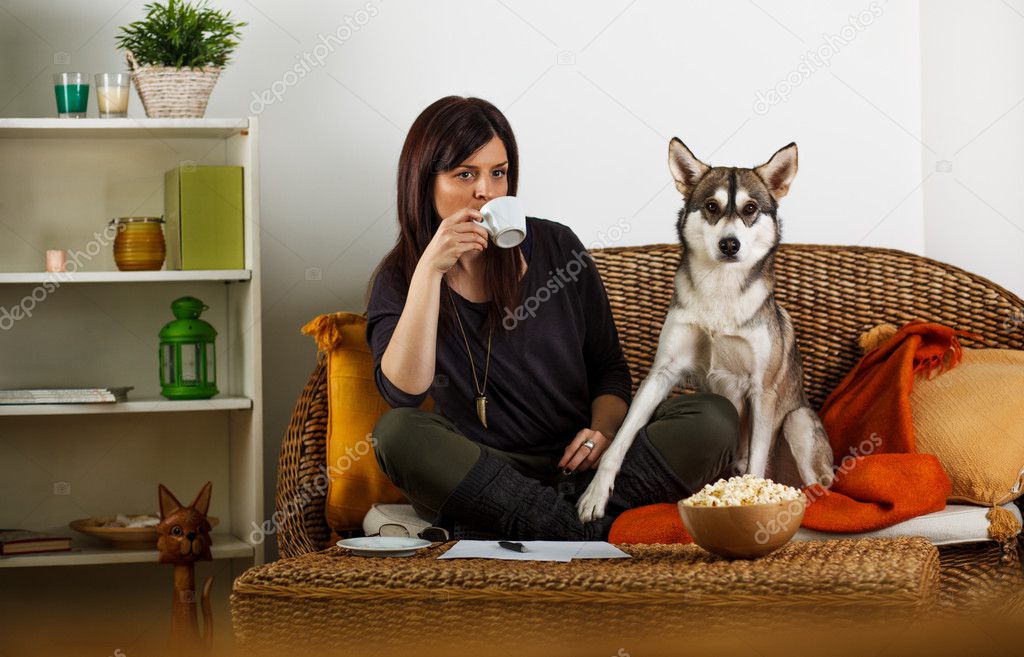 Young woman is playing with dog, at home