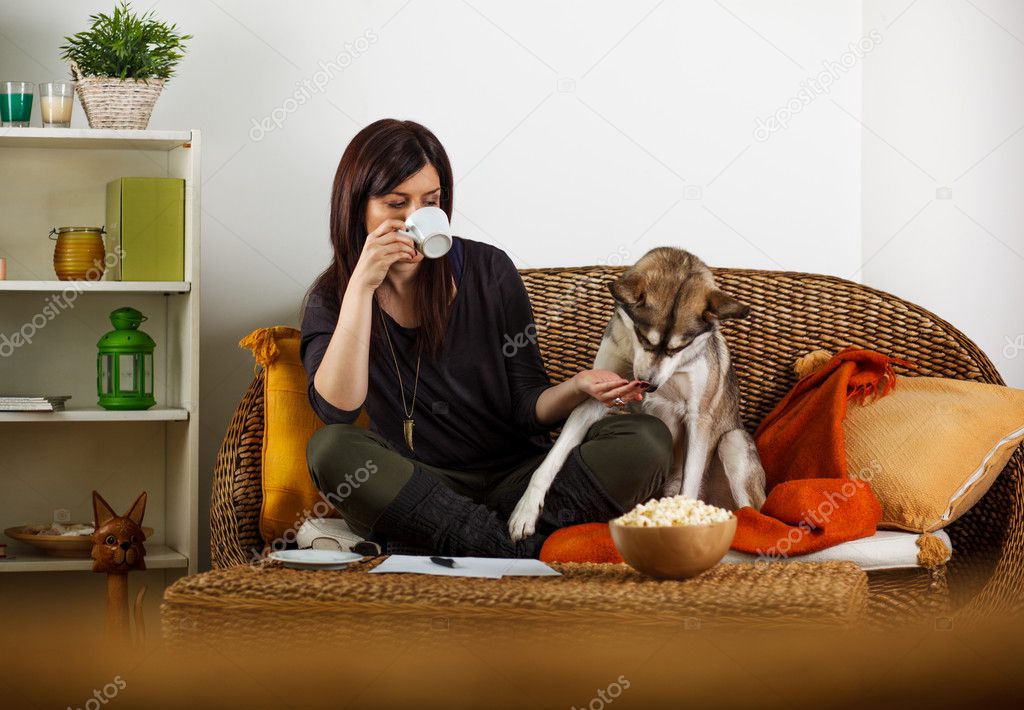 Young woman is playing with dog, at home