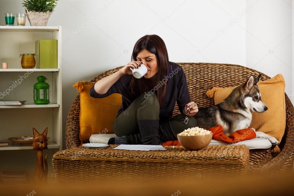 Young woman is playing with dog, at home