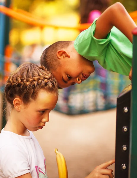 Ragazza caucasica e ragazzo afro americano, sul parco giochi nella scuola materna — Foto Stock