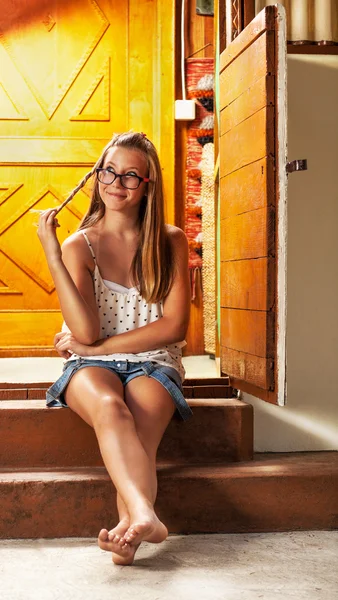 Menina caucasiana refrigeração na varanda da casa de madeira — Fotografia de Stock