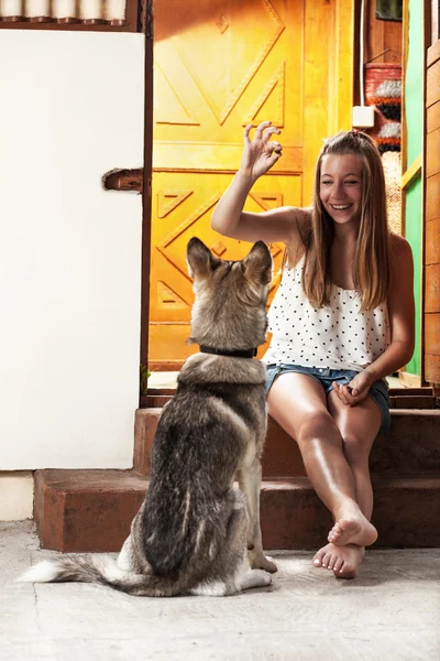 Adolescente menina alimentando cão — Fotografia de Stock