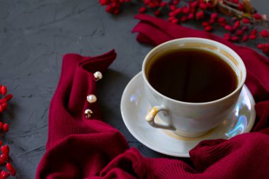 Sıcak espresso kahvenin ve inci düğmeli bordo renkli kazağın yakın görüntüsü. Sonbahar zamanı ve sakinlik kavramı.