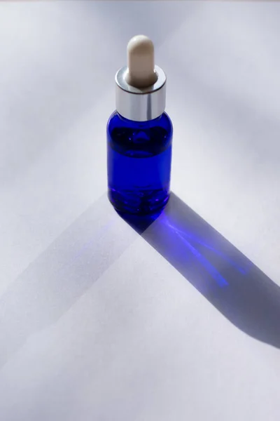 Vertical Format Photo Sunlit Blue Bottle Skin Care Serum White — Zdjęcie stockowe