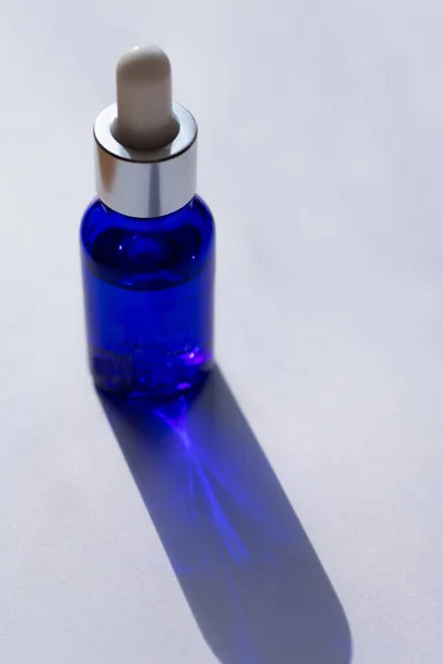 Вертикальная Фотография Синей Бутылки Пипеткой Полной Сыворотки Уходу Кожей Лица — стоковое фото