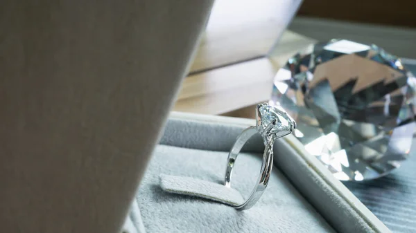 Close up of an elegant engagement diamond ring on woman finger while holding smart phone. love and wedding concept. Soft and selective focus.
