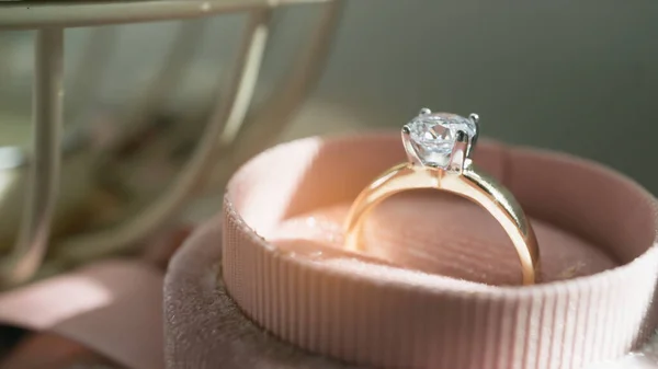 Close up of an elegant diamond ring in the box with sunlight and shadow background. love and wedding concept. Soft and selective focus.