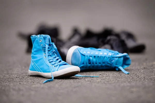 Blue sneakers on asphalt — Stock Photo, Image