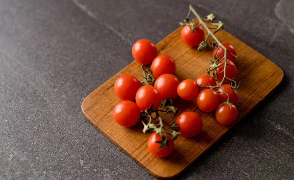 Tomates Rojos Cereza Sobre Fondo Piedra Oscura Tabla Cortar Madera — Foto de Stock