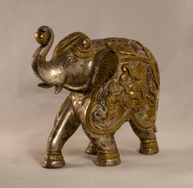 Beyaz arka planda bronzdan yapılmış bir Hint filinin heykeli.