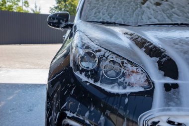 Oto yıkamada yıkanan siyah araba.