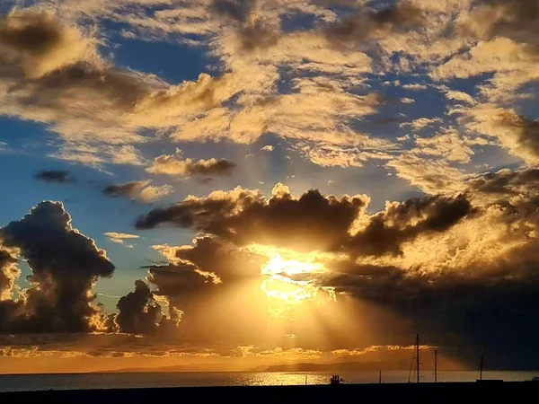 イタリアのジェノヴァ 2021年1月1日 美しい赤い空と背景にいくつかの素晴らしい色の雲と海とジェノヴァの港で冬の日の夕日の素晴らしい写真 — ストック写真