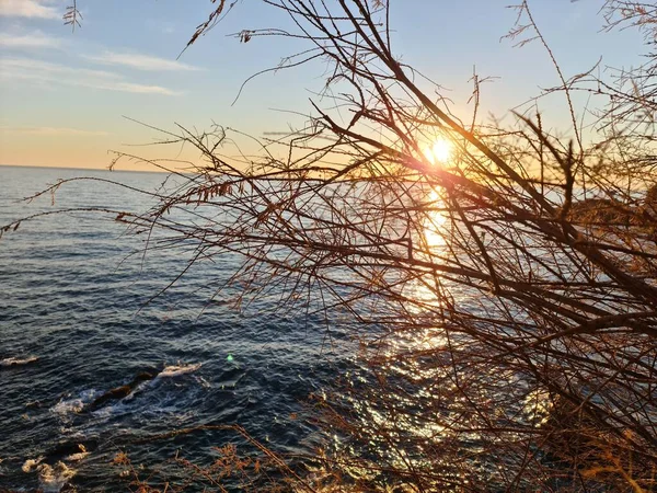 意大利热那亚 2022年1月28日 冬季美丽的落日 红色的云彩映在水面上 岩石附近的小海浪 — 图库照片