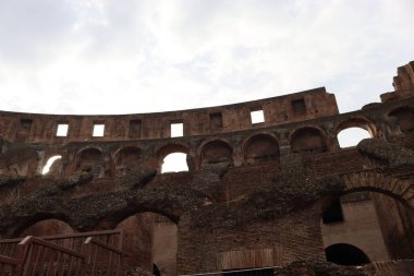 ROME, ITALY - 05 Şubat 2022: Roma, İtalya 'da Colosseum' un iç kısmının panoramik görüntüsü. Arka planda soğuk ve gri gökyüzü. Kemerlerin makro fotoğrafları.