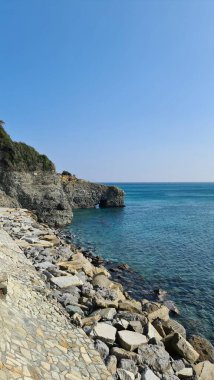 Savona, İtalya - 12 Şubat 2022: Mavi denizin panoraması, suyun üzerindeki ışık, okyanus gündoğumu. Kış günlerinde küçük dalgalar. Temiz gökyüzü suya yansıyor.