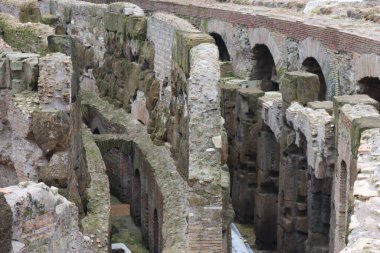 ROME, ITALY - 05 Şubat 2022: Roma, İtalya 'da Colosseum' un iç kısmının panoramik görüntüsü. Arka planda soğuk ve gri gökyüzü. Kemerlerin makro fotoğrafları.