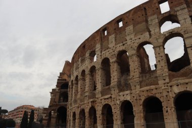 ROME, ITALY - 05 Şubat 2022: Roma, İtalya 'da Colosseum' un iç kısmının panoramik görüntüsü. Arka planda soğuk ve gri gökyüzü. Kemerlerin makro fotoğrafları.