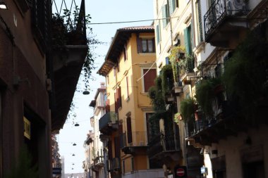 Verona, İtalya-19 Mart 2022: Verona 'nın güzel eski binaları. Ortaçağ 'ın tipik mimarisi. Arka planda mavi gökyüzü olan şehre hava görüntüsü.