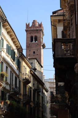Verona, İtalya-19 Mart 2022: Verona 'nın güzel eski binaları. Ortaçağ 'ın tipik mimarisi. Arka planda mavi gökyüzü olan şehre hava görüntüsü.