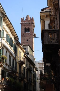 Verona, İtalya-19 Mart 2022: Verona 'nın güzel eski binaları. Ortaçağ 'ın tipik mimarisi. Arka planda mavi gökyüzü olan şehre hava görüntüsü.