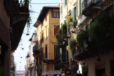 Verona, İtalya-19 Mart 2022: Verona 'nın güzel eski binaları. Ortaçağ 'ın tipik mimarisi. Arka planda mavi gökyüzü olan şehre hava görüntüsü.