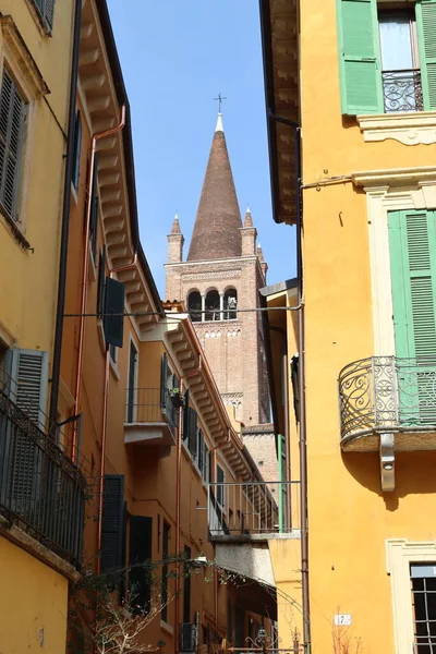 Verona, İtalya-19 Mart 2022: Verona 'nın güzel eski binaları. Ortaçağ 'ın tipik mimarisi. Arka planda mavi gökyüzü olan şehre hava görüntüsü.