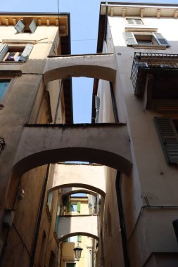 Verona, İtalya-19 Mart 2022: Verona 'nın güzel eski binaları. Ortaçağ 'ın tipik mimarisi. Arka planda mavi gökyüzü olan şehre hava görüntüsü.