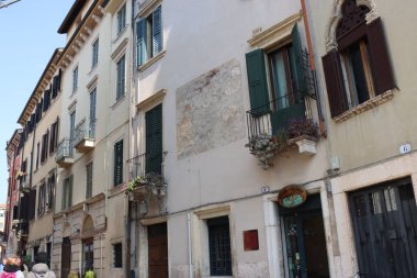 Verona, İtalya-19 Mart 2022: Verona 'nın güzel eski binaları. Ortaçağ 'ın tipik mimarisi. Arka planda mavi gökyüzü olan şehre hava görüntüsü.