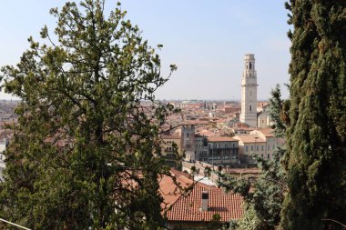 Verona, İtalya-19 Mart 2022: Verona 'nın güzel eski binaları. Ortaçağ 'ın tipik mimarisi. Arka planda mavi gökyüzü olan şehre doğru hava manzarası, nehre ulaşmak için güzel bir manzara..